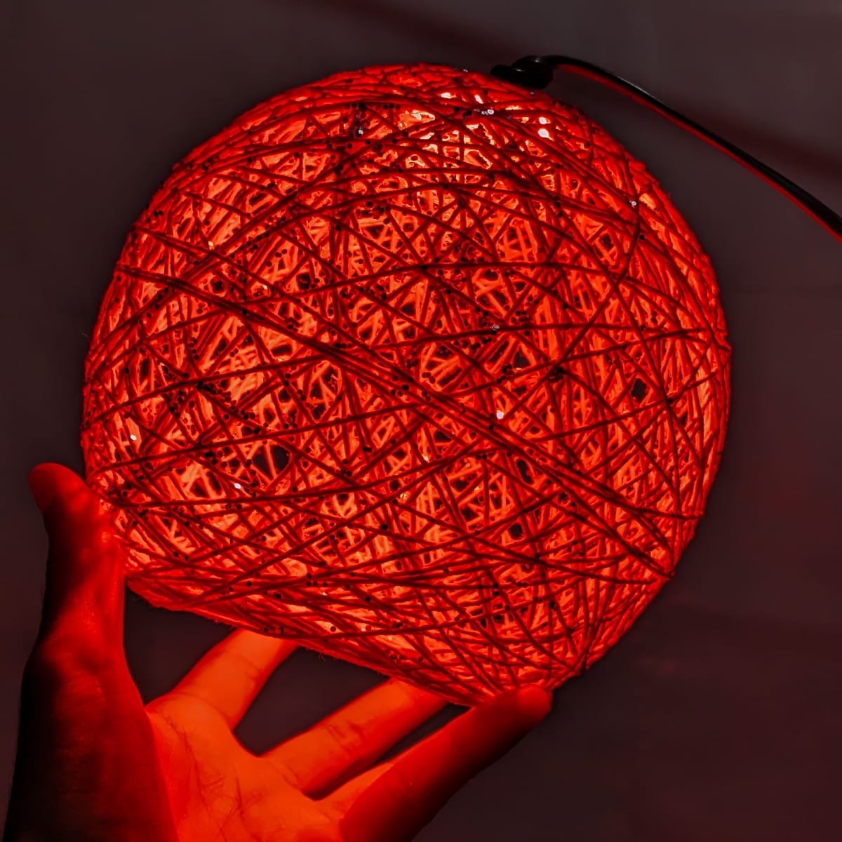 String ball lamp displayed on a table or shelf as a home decoration accessory.